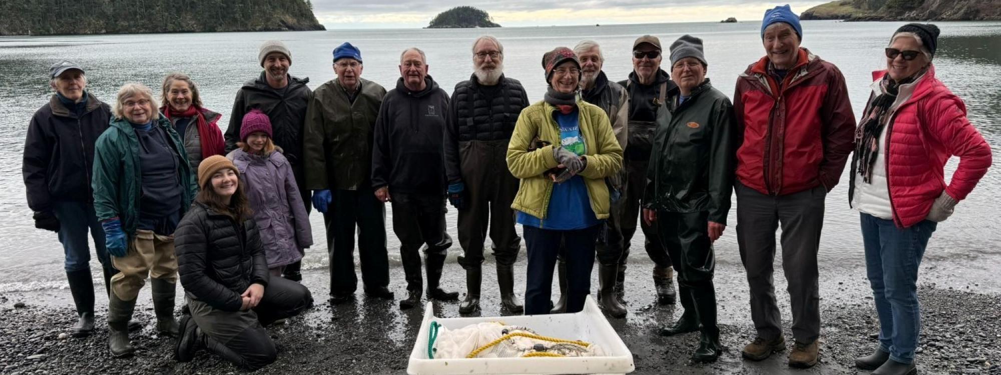 Volunteer appreciation celebration at Bowman Bay with members of Skagit MRC and Salish Sea Alliance, honoring volunteers who’ve supported MRC work for over a decade. The tub in front holds the beach seining gear managed by Paul Dinnel, a Skagit MRC member who’s been part of the beach seining effort since day one! (Lisa Kaufman).